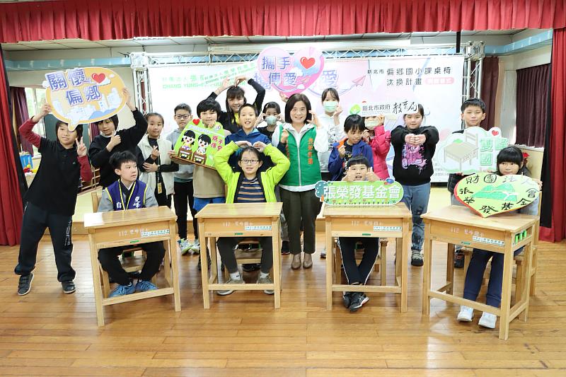 張榮發基金會執行長鍾德美(中著綠背心)勉勵學生有了新桌椅要更認真求學。
