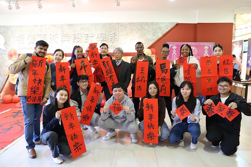 南華大學視設系舉辦「春納-迎春納福」活動，葉宗和院長(後排中)帶領師生揮毫寫春，外籍生也歡喜參與。