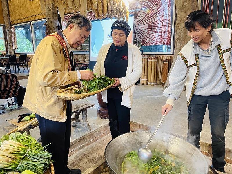 花蓮縣光復鄉太巴塱社區營造協會專案經理人玲玲(中)向許次長介紹部落野菜，理事長蕭明山(右)現場烹煮野菜湯