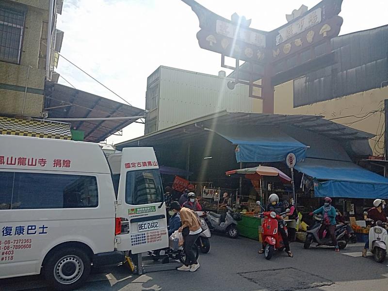 屏縣府復康巴士接送身心障礙者至屏東市北區市場購買年菜。