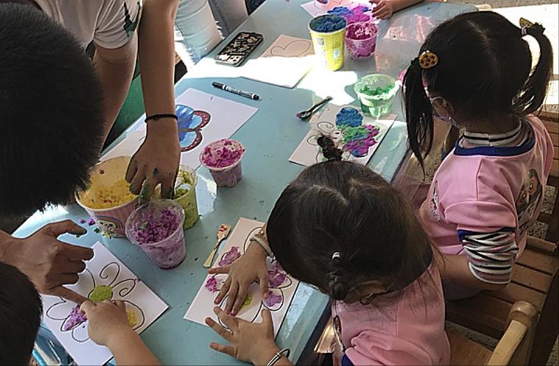 南臺科大幼保學生教導學甲幼兒彩塗蝴蝶新衣。