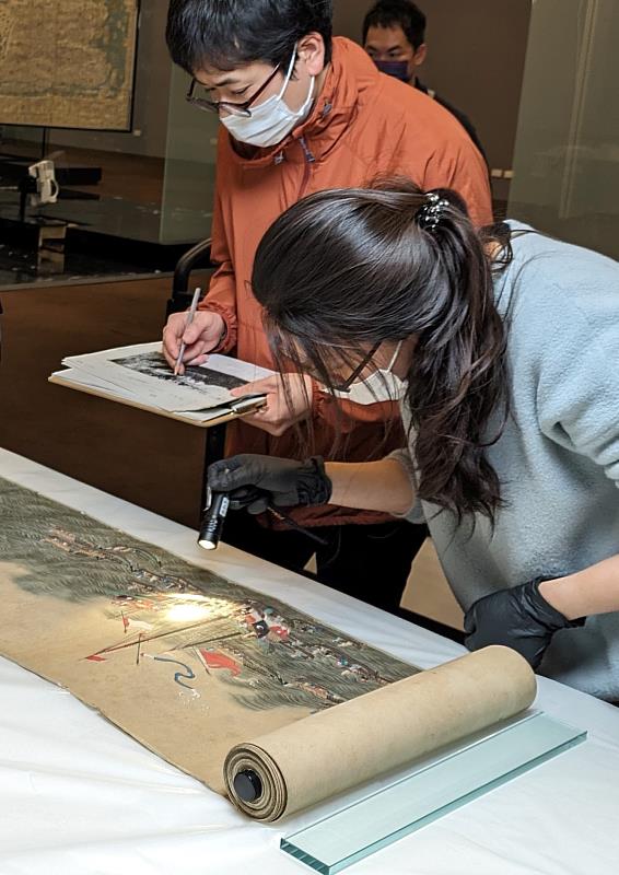 臺史博文保人員（圖右）與日本神戶市立博物館研究人員（圖左）共同檢視該館文物「長崎唐館交易圖巻」。