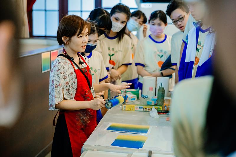 435聚落藝術家游雅蘭在環境美化工創工作坊中，指導版畫油墨的漸層滾印技法