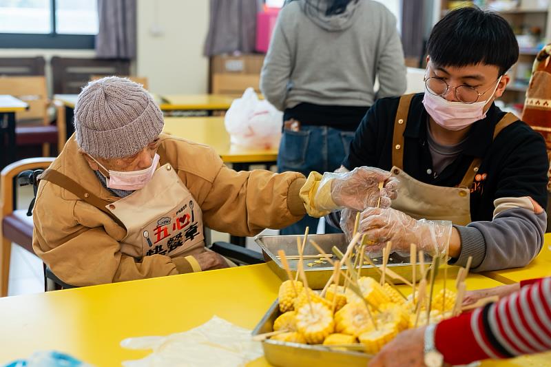 陳文魁阿公和照顧服務員分工合作，一起串食材