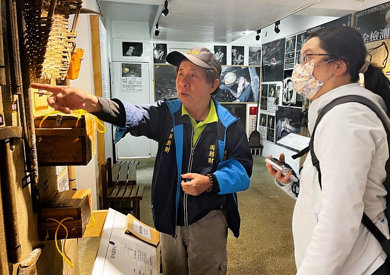 新北市猴硐礦工文史協會小周哥(左)為遊客介紹猴硐礦業歷史及當初的採礦工具