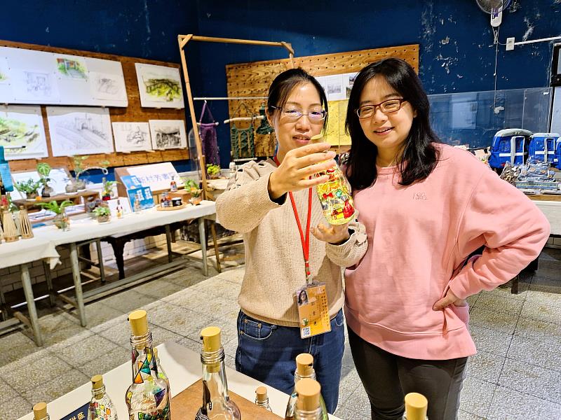 新北市瑞芳老街文化觀光推展協會進用二度就業的小彭姐(左)，為遊客介紹彩繪瓶燈與礦業文化