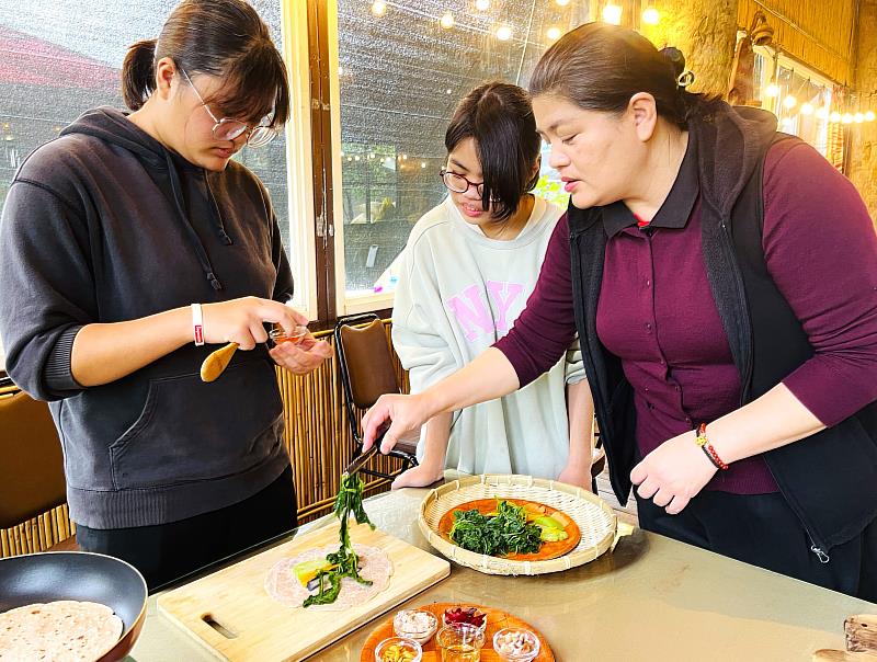 光復太巴塱協會專案經理劉燕玲(右)教導部落青少女製作紅糯米手作野菜捲餅，讓部落米食文化向下札根傳承