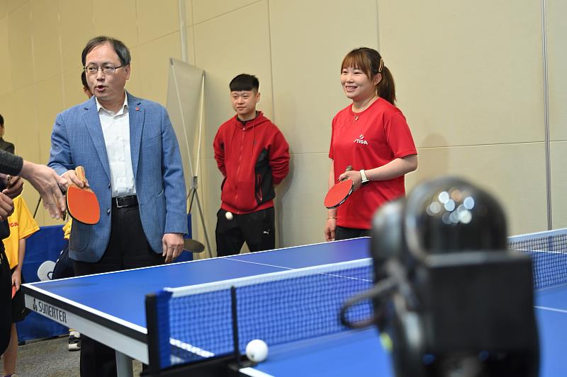 外貿協會秘書長王熙蒙體驗乒乓球機器人。(貿協提供)