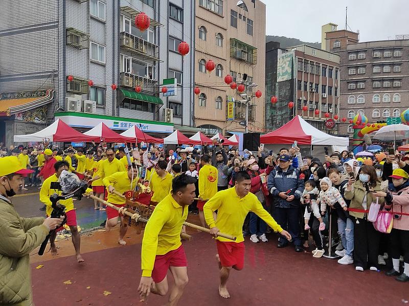 由在地子弟四人一組抬轎助跑跳入港區