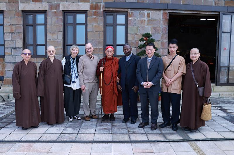 心道法師（中）與鮑霖神父（右四）、輔仁大學副校長林之鼎神父（右三）等一行在開山聖殿外合影。（圖由靈鷲山佛教教團提供）