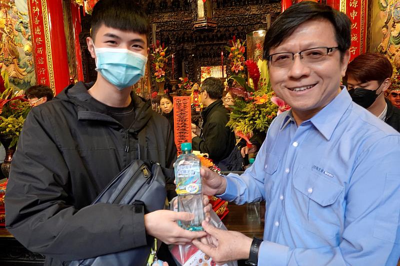 臺鹽公司總經理陳世輝（右）發送台塩海洋鹼性離子水大甲媽祈福瓶給香客，大受歡迎。