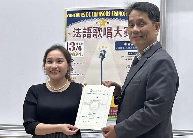 徐輝明校長頒發獎狀給獲得第一名的音樂系同學何鎵薰。