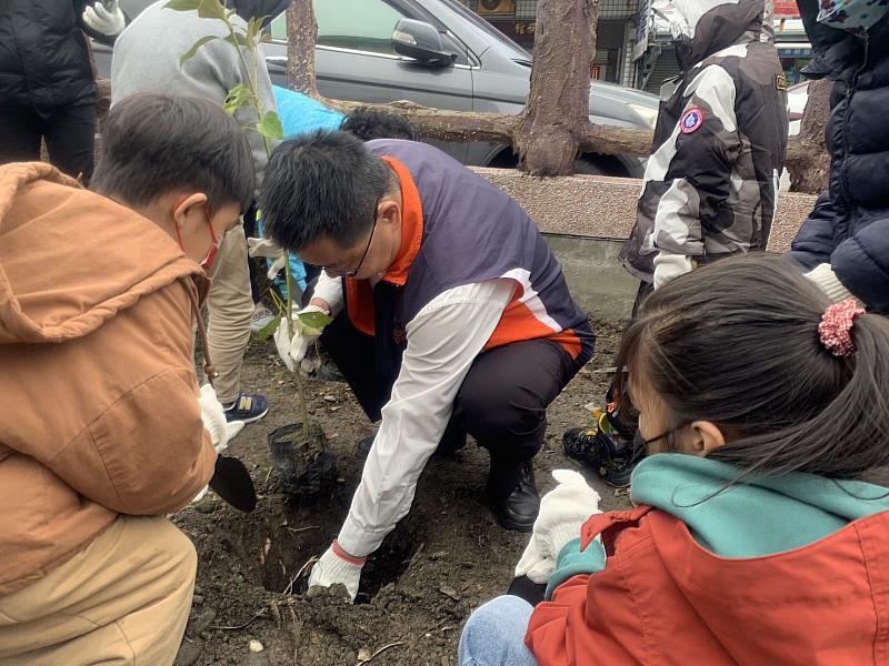 成功站主任與成功鎮立幼兒園小朋友攜手一起為風災後的宿舍周圍種樹，象徵家園重建