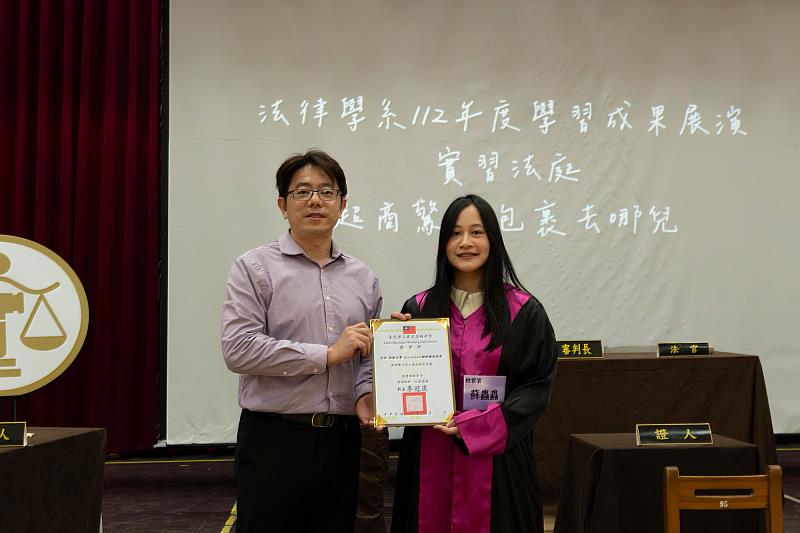 萬芳高中校長李冠達（左）致贈感謝狀予世新法律系學生蘇琮涵。（世新大學提供）