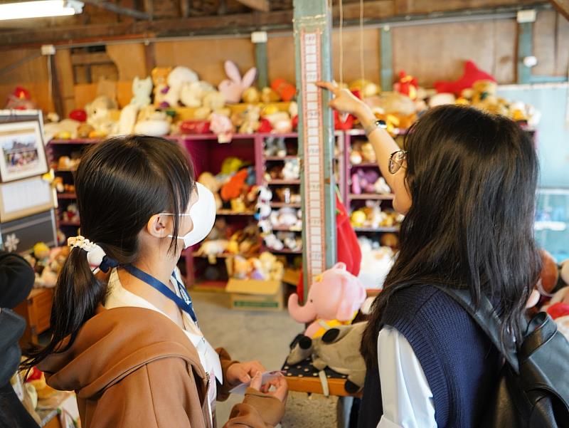 孩子扮演解說員與國際大學生介紹娃娃屋。