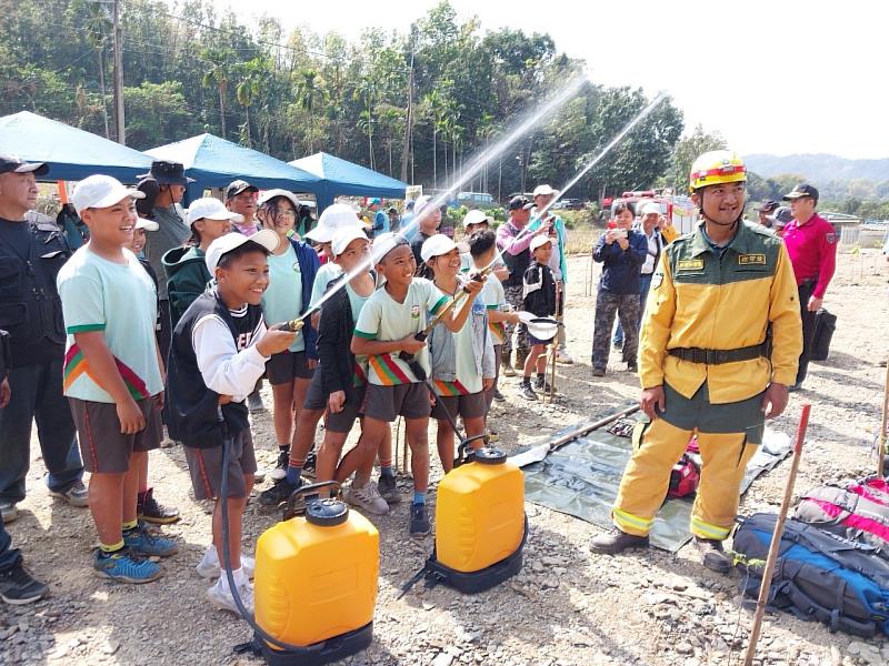 自然及保育署屏東分署同仁教導學童使用背負式水帶滅火