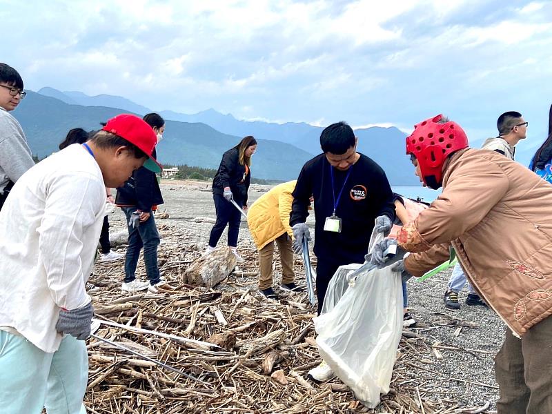 在南山志工陪伴帶領下，愛奇兒用夾子在海灘撿拾垃圾，一起為地球環境永續努力。