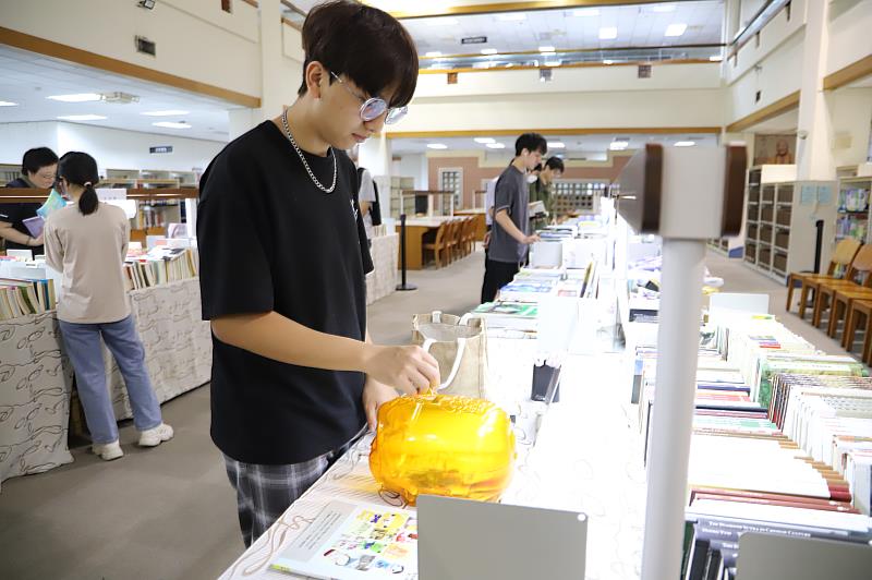 南華大學圖書館舉辦「良心商店-好書義賣」，學生參與踴躍，學生自行投幣購書。