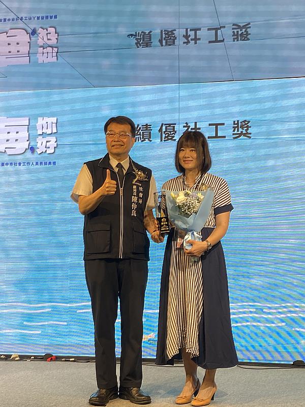 蕭伊伶社工師獲頒臺中市績優社工獎,與臺中市社會局副局長陳仲良(左)合影