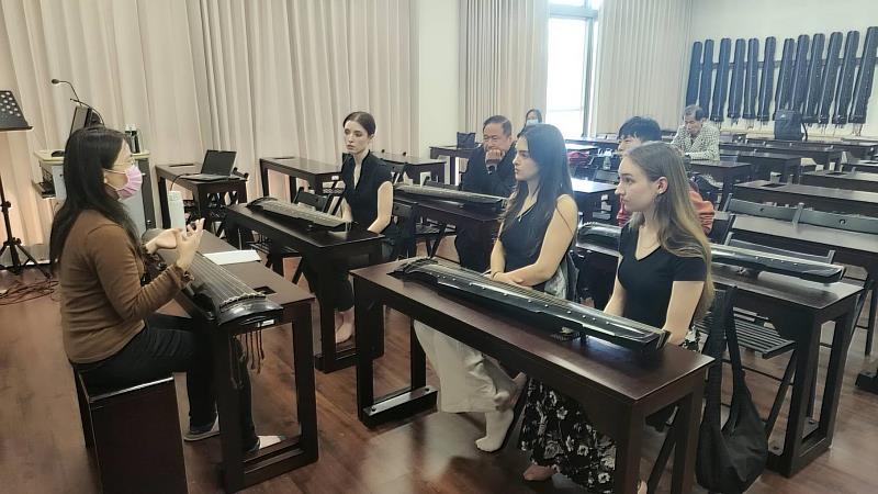 美國三一大學師生蒞南華大學民音系進行移地學習，民音系副主任張雅婷(左)教導古琴演奏。