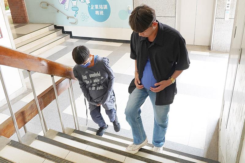 參訪大葉的學生穿上孕婦體驗裝爬樓梯