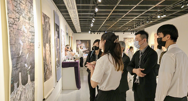 南華大學視設系畢展「趨同」巡迴展開跑，參展學生向師長及參觀者介紹作品。