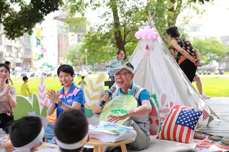 環保局長江盛任與小朋友一起席地而坐講繪本