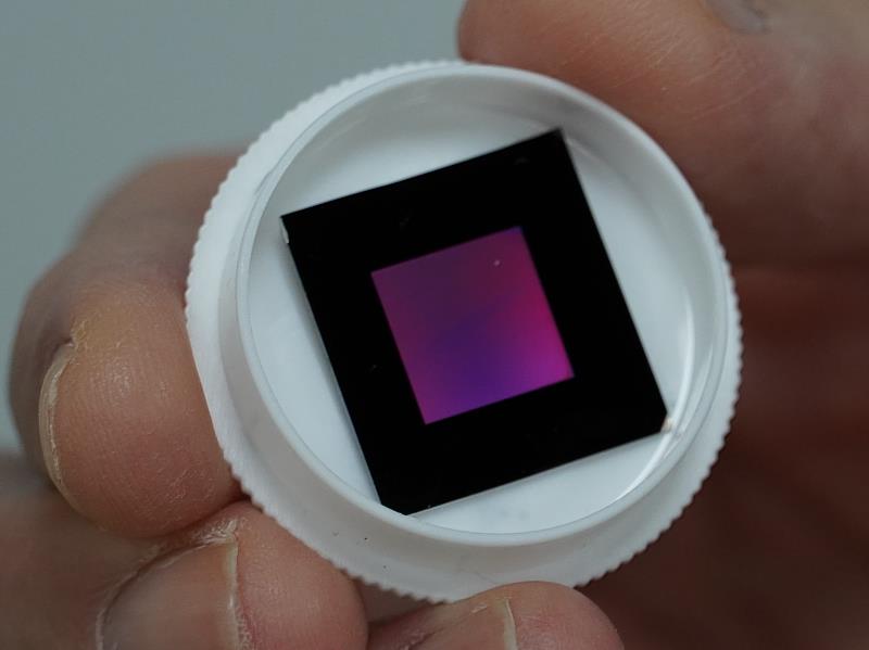 臺科大團隊運用半導體製程與濺鍍技術，可在小範圍的晶圓上製造出逾2500萬支的金屬玻璃奈米管，如相片中彩色亮光的區域所示。