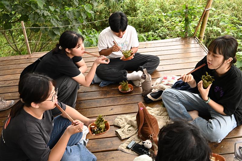 學生在大自然中享受原住民族風味餐及用林投葉編製的阿里鳳鳳。
