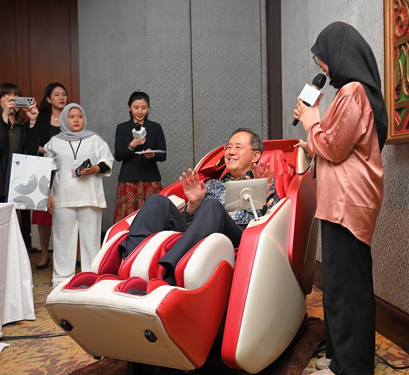 駐印尼台北經濟代表處組長路豐璟體驗參展商-督洋生技展示的按摩椅。(貿協提供)