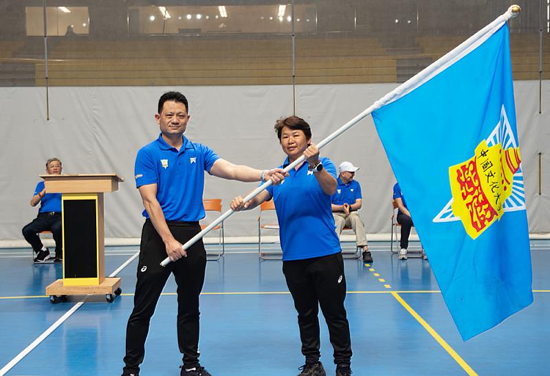 文化大學體育室黃士魁老師授旗于陳麗如選手，鼓勵全體運動員為校爭光