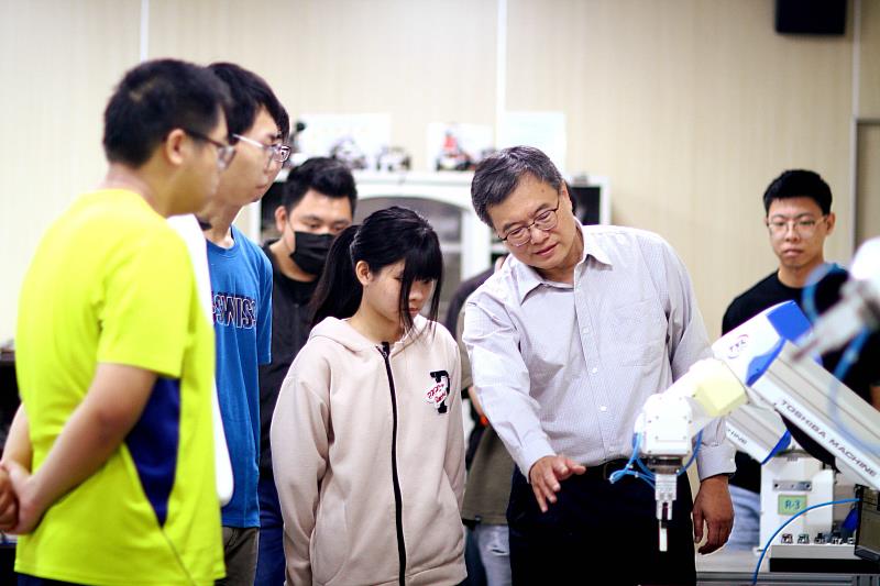 圖說：楊錫凱老師(右一)指導實驗室學生使用機械手臂。(圖/中信科技大學提供)