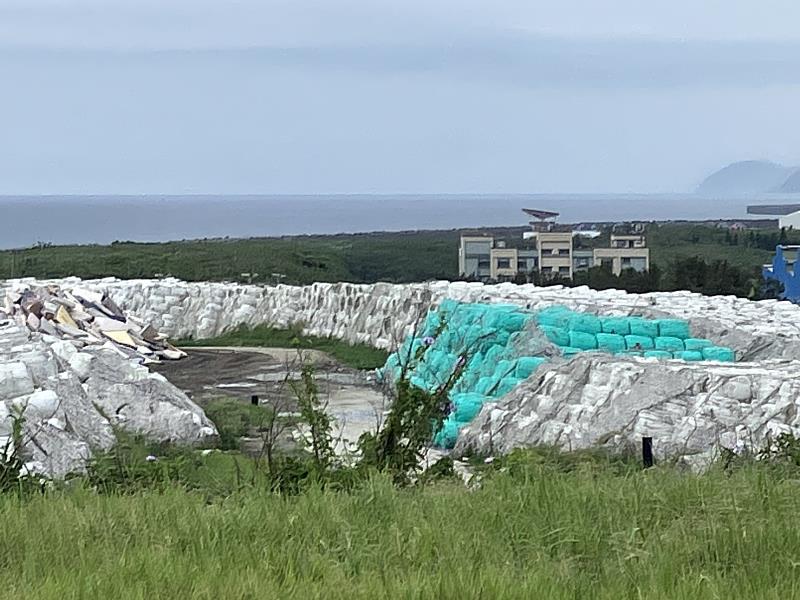 從環保公園可以清楚看到海邊的垃圾掩埋場大量暫置的打包垃圾，左側還可以看到床墊山。