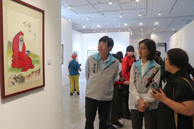 參展藝術家范天送家屬范素鑾，向張秘書長介紹作品