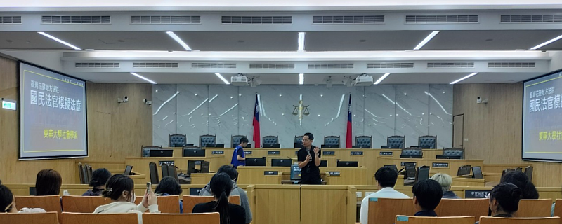 花蓮地方法院吳明駿庭長（中間站立者）在設備完善的國民法官法庭對師生做解說。