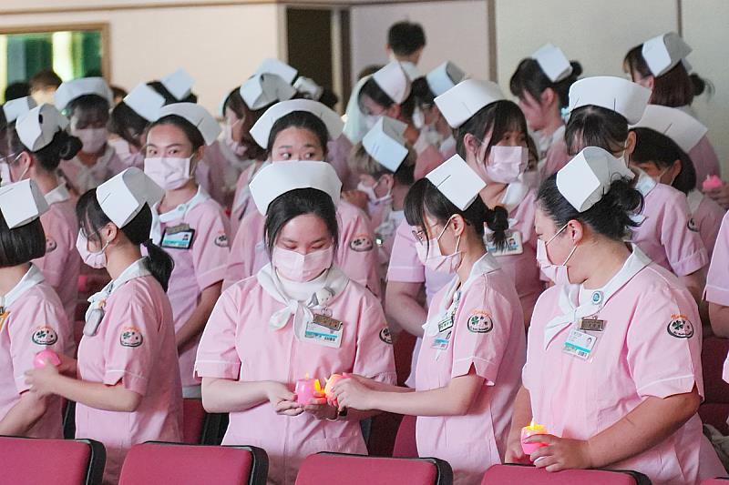 義守大學在國際護師節前，舉辦加冠典禮，學子們手拿閃爍的燭光燈，也成為點亮病人在面對困境時的明燈(照片來源：義守大學提供)。