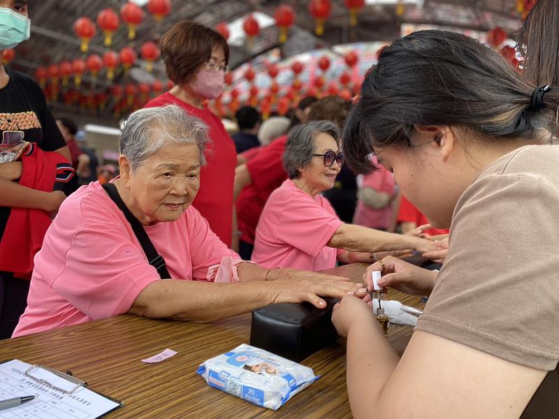 中臺科大彩繪金尬藝術社幫社區奶奶做手部保養