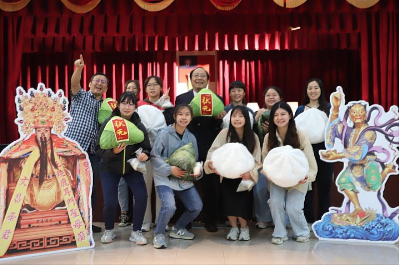 報名參加國家專技高考的學生開心拿著包子和粽子，與文昌帝君和魁星爺合照