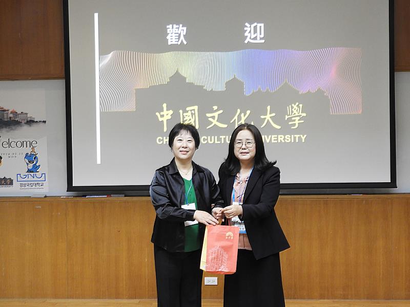文化大學韓文系鄭潤道主任(左)與慶尚大學姜貞和學務長(右)交換禮物。