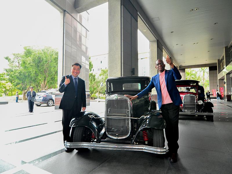 聖露西亞皮耶總理(右)特別在崑大師生共同改造的古董電動車前合影，左為李天祥校長