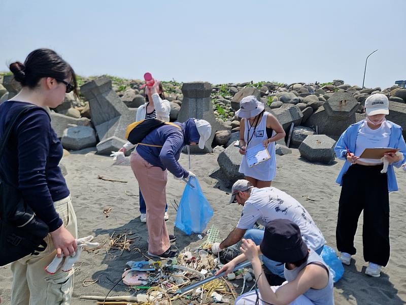 參加海洋塑膠汙染意識週末活動的學生和老師 ，前往蚵仔寮淨灘，將塑膠垃圾集中與分類。