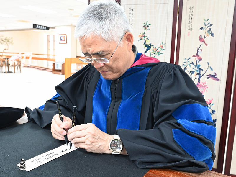 南華大學畢業典禮前夕，高俊雄校長以雙管齊下書寫星雲大師法語祝福畢業生。