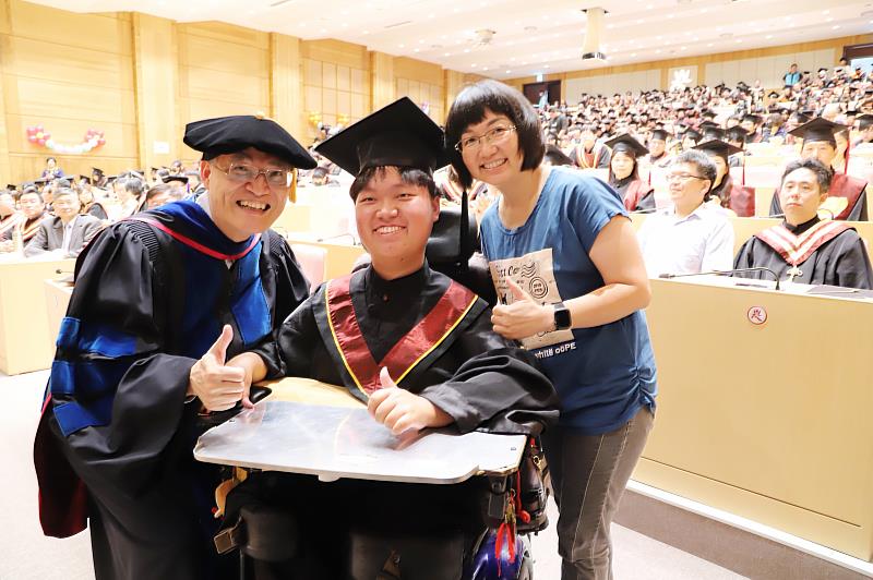 南華大學舉辦畢業典禮，高俊雄校長(左)為傳播學系罹患脊髓性肌肉萎縮症的林育陞同學(中)撥穗並合影。右為林育陞同學母親。