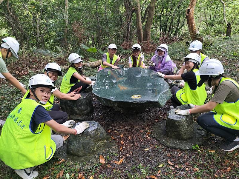 文藻志工學生協助清理雙流國家公園戶外石桌表面的青苔，提升遊客使用的安全性。