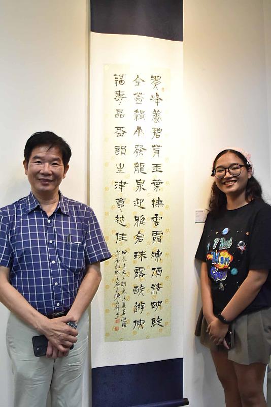 臺中市政府參事陳志聲（左）展岀作品〈詠茶〉深受華梵同學歡迎。