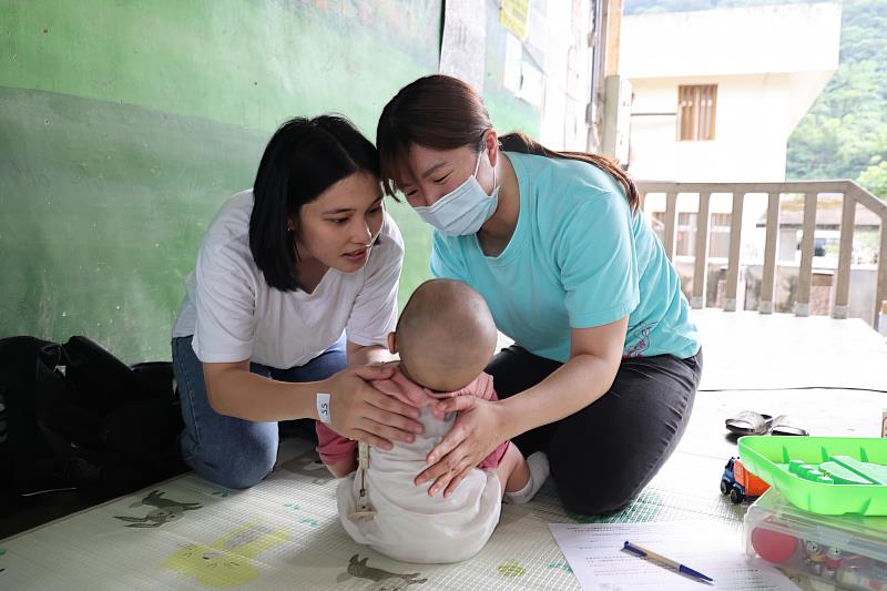 花蓮慈院兒童發展復健中心職能治療師邱心莉(右)仔細評估寶寶的各項能力。