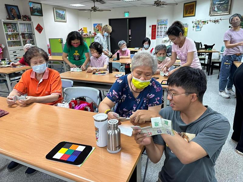 黃彥愷(右)在社區協助長輩進行手作活動