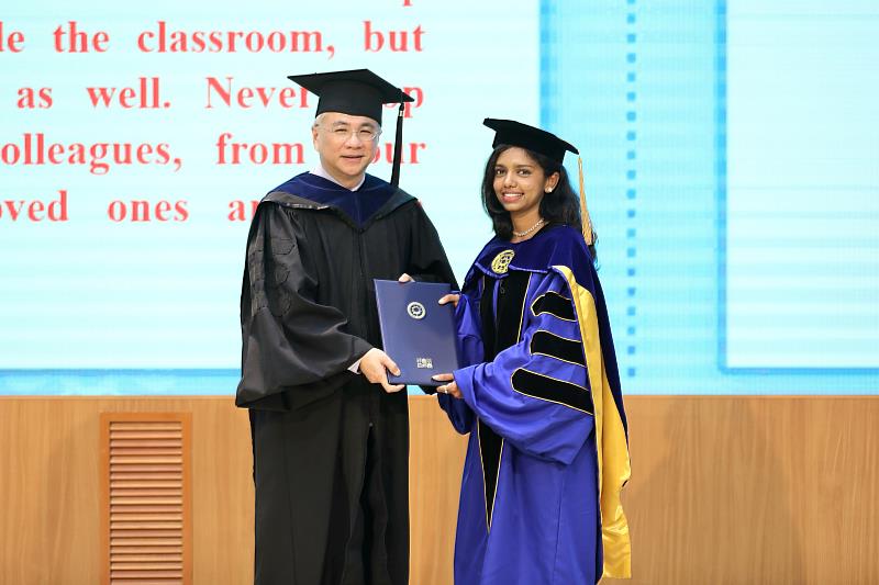 朝陽科大校長鄭道明(左)為應用化學系印度籍生化科技博士畢業生代表PRATIMA(右)正冠並授予學位證書。