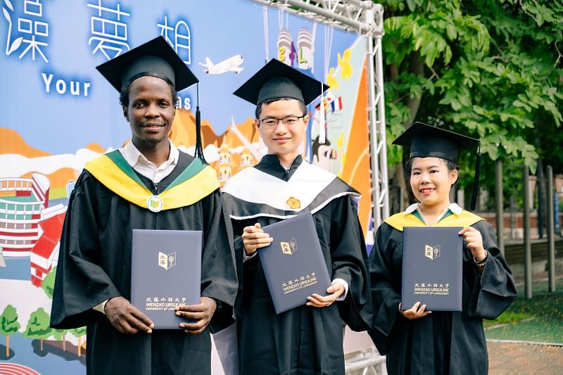 肯亞籍歐杰明(左)、泰國籍寶宏娜(右)及於在學期間已通過「112年外交領事人員考試」的呂懷哲(中)，於校園合影留念。