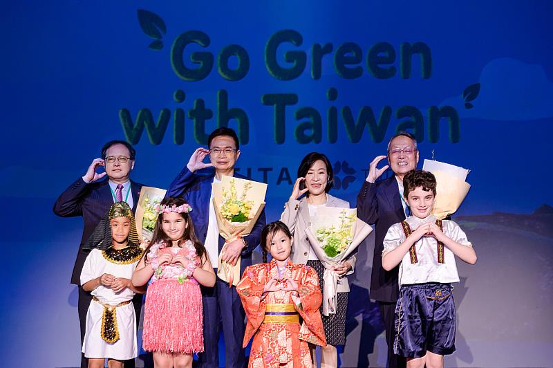 身穿國際民族服飾的孩童獻花予「 Go Green with Taiwan 全球徵案活動」啟動記者會貴賓，象徵各國合作為下一代打造綠色、永續的未來 (左起：外貿協會秘書長王熙蒙、外貿協會董事長黃志芳、經濟部國際貿易署署長江文若、活動榮譽大使宏碁集團創辦人暨榮譽董事長施振榮)。(貿協提供)